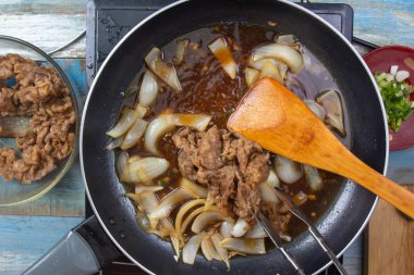 Şef koymak kaydırmak için pişmiş sığır eti dilim / Japon yemek pişirme Gyudon kavramı