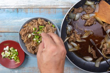 aşçı pirinç pişmiş sığır eti dilim soğan koymak / Japon yemek pişirme Gyudon kavramı