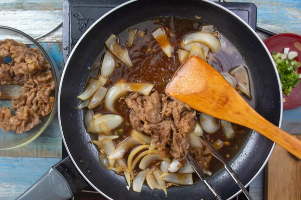 Şef koymak kaydırmak için pişmiş sığır eti dilim / Japon yemek pişirme Gyudon kavramı