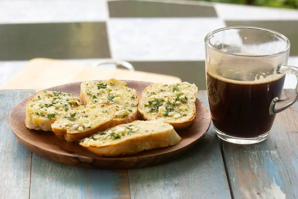 Garlic bread on the wooden plate with black coffee/ Cooking Garlic bread concept