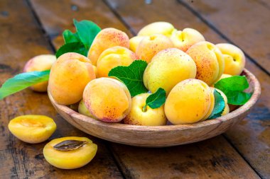 Ahşap tabak içinde sarı kayısılar. 