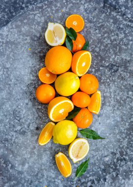 gri masa yüzeyinde taze lezzetli mandalina, limon ve portakal