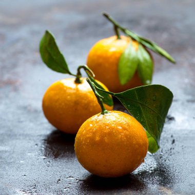 Masa yüzeyinde ıslak turuncu mandalinalar