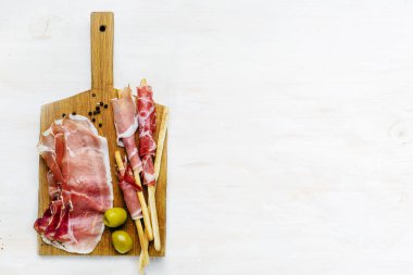 ahşap tahta jambon et dilimleri, ekmek ve yeşil zeytin üst görünümü
