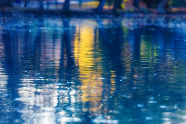Reflexão turva do pôr do sol sobre a água ao anoitecer — Fotografia de Stock
