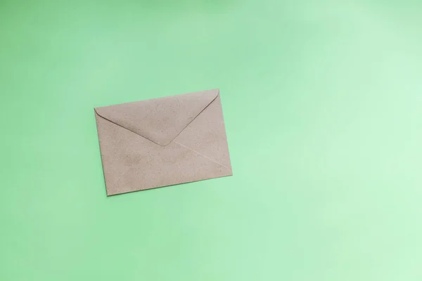 Крафт бумажные конверты на зеленом фоне — стоковое фото