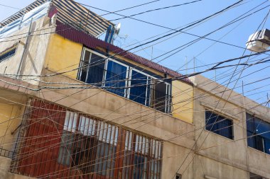 Mavi gökyüzü ve binaların arka planında kablo ve kablo karışıklığı. Lübnan 'daki Baalbek kasabasının sokak manzarası