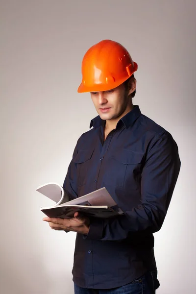 Businessman in protective helmet over a gray background — Stock Photo, Image