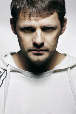 Spor kapüşonlu beyaz beyaz bir erkek portresi.