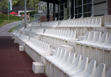 Stadyum taraftarları bölgesinde beyaz koltuklar. Küçük bir stadyumdaki Grandstand taraftarları. Spor etkinlikleri için yer.