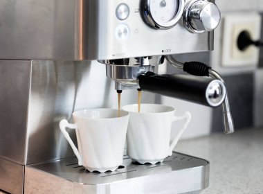 Bir kahve makinesi mutfakta espresso yapar. 2 fincan kahve.. 