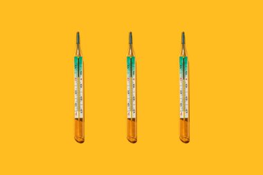 Arka arkaya üç medikal civa termometresi, yakın plan, düz alan.