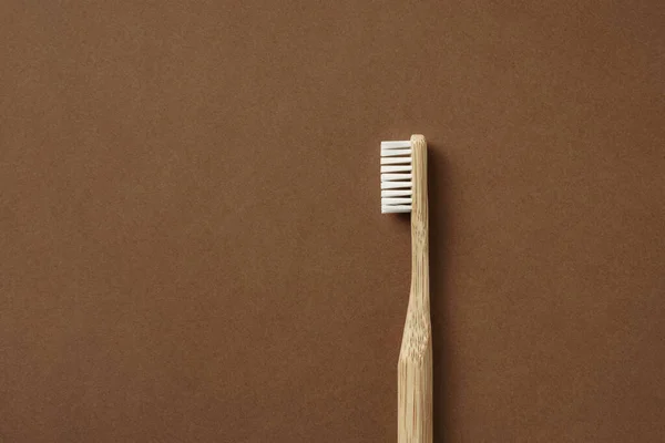 Бамбукова зубна щітка на коричневому фоні — стокове фото