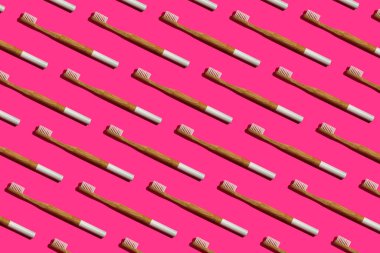 Pembe arka planda bambu diş fırçaları.
