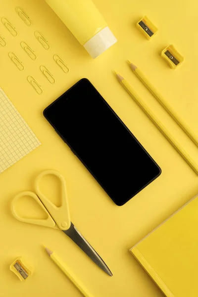Czarny smartfon makieta, ołówki, spinacze do papieru, nożyczki, temperówki — Zdjęcie stockowe