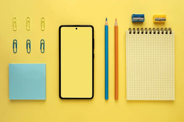 Yellow flat layout of office workplace with stationery