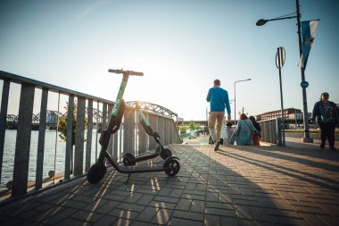 Kiralık elektrikli scooter şehir sokaklarında park, Çevre dostu ulaşım.