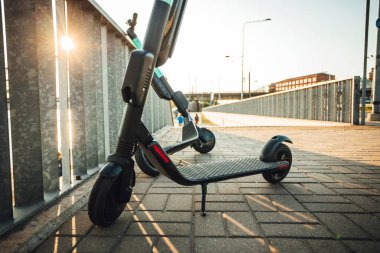 Kiralık elektrikli scooter şehir sokaklarında park, Çevre dostu ulaşım.
