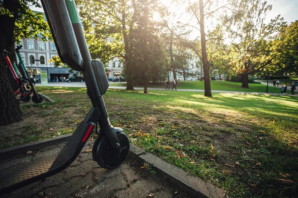 Kiralık elektrikli scooter şehir sokaklarında park, Çevre dostu ulaşım.