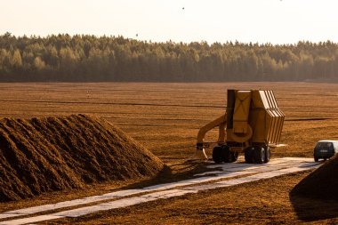 Gün batımı nda ekskavatör traktörü ile çim çıkarma alanı, turba alanı