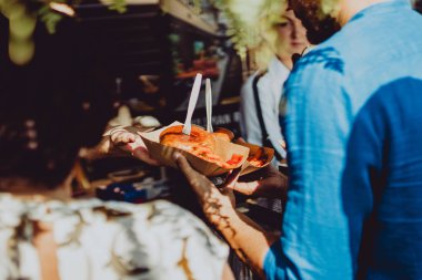 Cesis, Letonya 26 Haziran 2019 Sokak Gıda Festivali Yemeği. İnsanlar açık hava pazarında taze yemek yiyor.