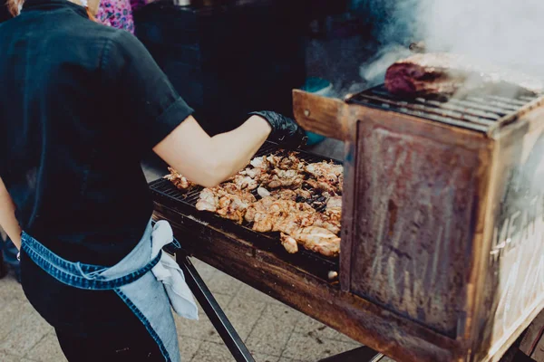 Street food festival, cooks preparing food in outdoor market