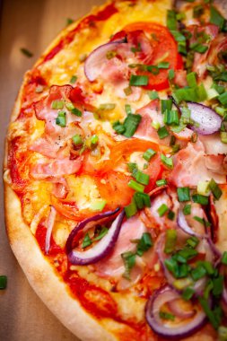 Pizzaya et, sebze, soğan ve salamlı yakından bakın. 