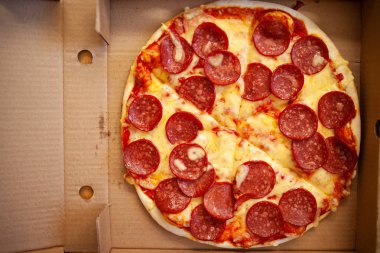 Kutudaki pizza ve salam manzarasını kapat. İtalyan yemeği.