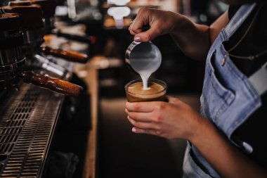 Barista bir kafede kahve yapıyor..