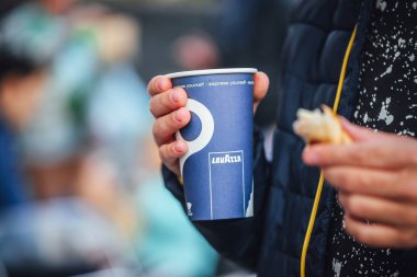 Riga, Latvia september 23.2019 Blue Lavazza Paper Coffee Cup from vending machine in kid hands
