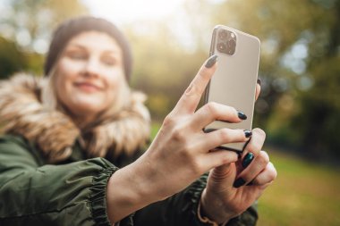 Riga, Latvia september 23, 2019 Woman using iphone 11 pro for photography, triple smartphone camera in close up