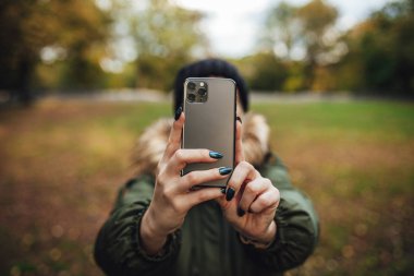 Riga, Latvia september 23, 2019 Woman using iphone 11 pro for photography, triple smartphone camera in close up