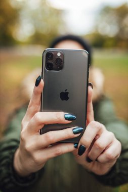 Riga, Latvia september 23, 2019 Woman using iphone 11 pro for photography, triple smartphone camera in close up