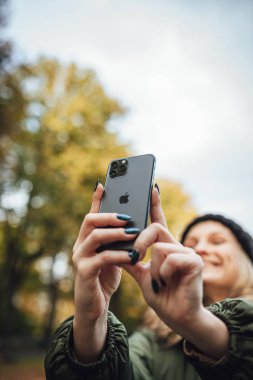 Riga, Latvia september 23, 2019 Woman using iphone 11 pro for photography, triple smartphone camera in close up