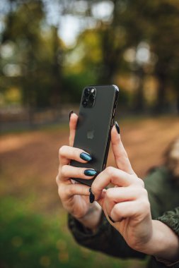 Riga, Latvia september 23, 2019 Woman using iphone 11 pro for photography, triple smartphone camera in close up