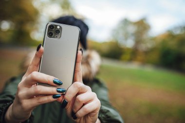 Riga, Latvia september 23, 2019 Woman using iphone 11 pro for photography, triple smartphone camera in close up