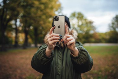 Riga, Latvia september 23, 2019 Woman using iphone 11 pro for photography, triple smartphone camera in close up