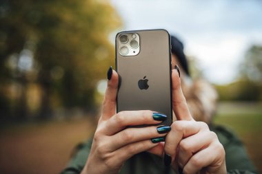 Riga, Latvia september 23, 2019 Woman using iphone 11 pro for photography, triple smartphone camera in close up
