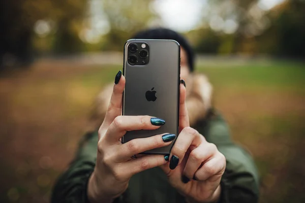Riga, Latvia september 23, 2019 Woman using iphone 11 pro for photography, triple smartphone camera in close up