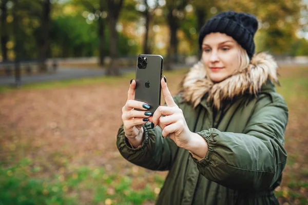 Riga, Latvia september 23, 2019 Woman using iphone 11 pro for photography, triple smartphone camera in close up