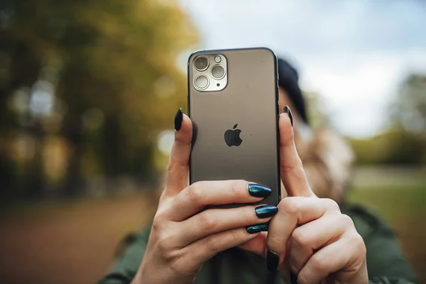 Riga, Latvia september 23, 2019 Woman using iphone 11 pro for photography, triple smartphone camera in close up