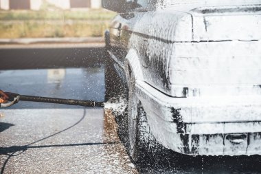 Temizlik sırasında köpükle kaplı araba, araba yıkama işlemi, çorbayla kaplı araba.