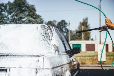 Temizlik sırasında köpükle kaplı araba, araba yıkama işlemi, çorbayla kaplı araba.
