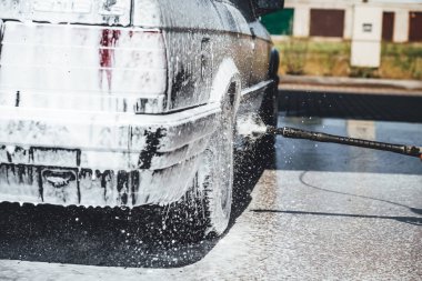 Temizlik sırasında köpükle kaplı araba, araba yıkama işlemi, çorbayla kaplı araba.