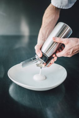 Michelin şefi karanlık masada balık yemeği hazırlıyor.