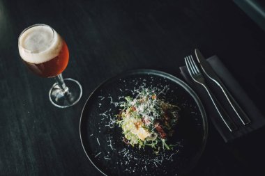 Sağlıklı ve lezzetli tavuk. Koyu masa üzerinde pancar, restoranda bir bardak bira, aşçı yemek yapıyor..