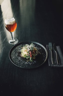 Sağlıklı ve lezzetli tavuk. Koyu masa üzerinde pancar, restoranda bir bardak bira, aşçı yemek yapıyor..