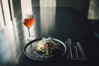 Sağlıklı ve lezzetli tavuk. Koyu masa üzerinde pancar, restoranda bir bardak bira, aşçı yemek yapıyor..