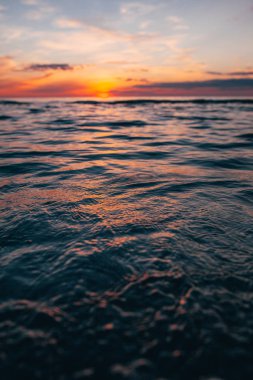 Deniz kenarında bir akşam, Baltık kıyılarında güzel bir gün batımı, küçük dalgalar üzerinde yakın bir manzara.