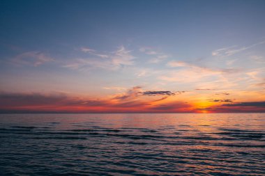 Deniz kenarında bir akşam, Baltık kıyılarında güzel bir gün batımı, küçük dalgalar üzerinde yakın bir manzara.